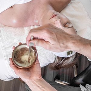 Esthetician mixing up facial treatment prior to applying it to a client's face